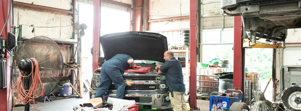 Two Diesel Pros technicians working on a truck in the Hurst, TX shop
